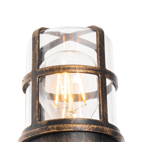 Außenwandleuchte mit zylindrischem Glasschirm und Metallkäfig im Antik-Look, inklusive LED-Filament-Leuchtmittel.