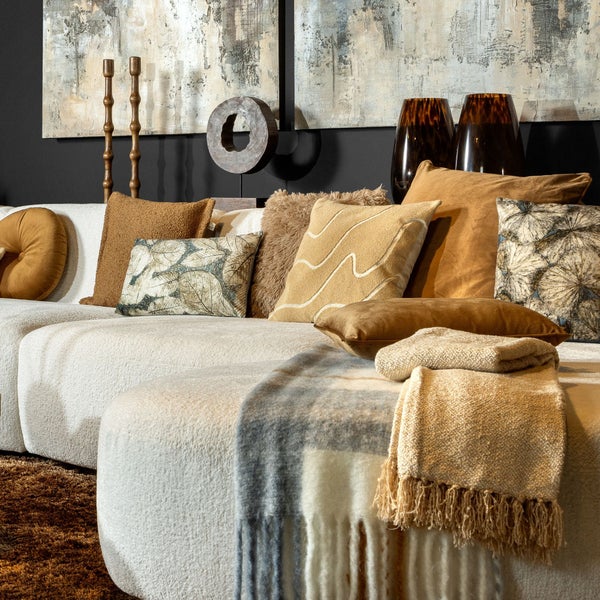 Dekoratives Wohnzimmer mit modularem Sofa, Kissen, Decken, Kerzenständern und Vasen