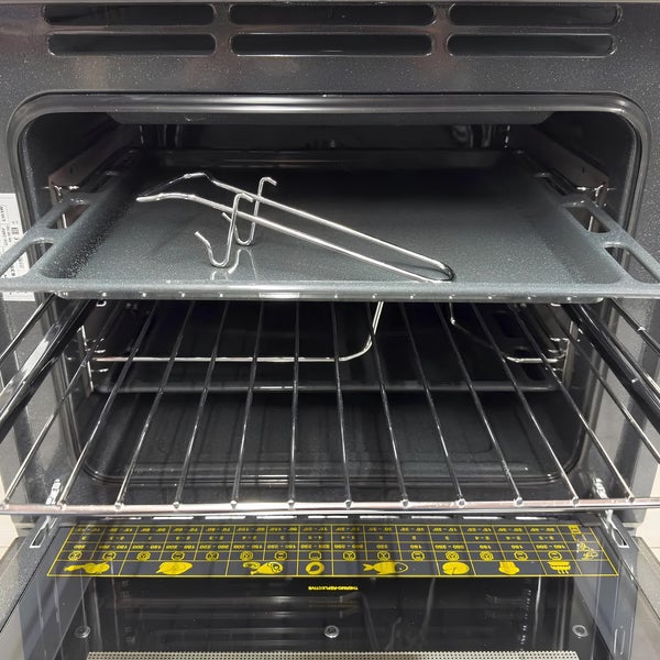 Backofen mit integriertem Backblech und Grillrost sowie einem Backblechgriff für die sichere Handhabung im Innenraum.