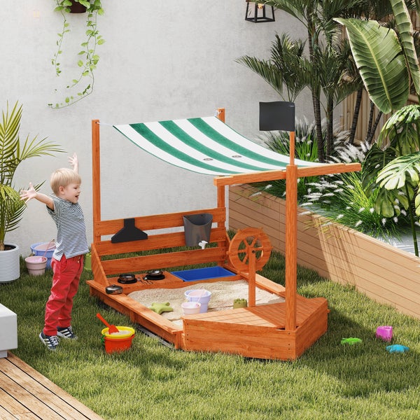 Sandkasten aus Holz mit Markise, Spielküche und Wasserrad im Garten