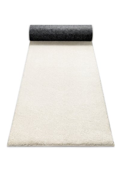 Hochflor-Teppichläufer in Creme, teilweise aufgerollt mit einer dunkelgrauen Rückseite.