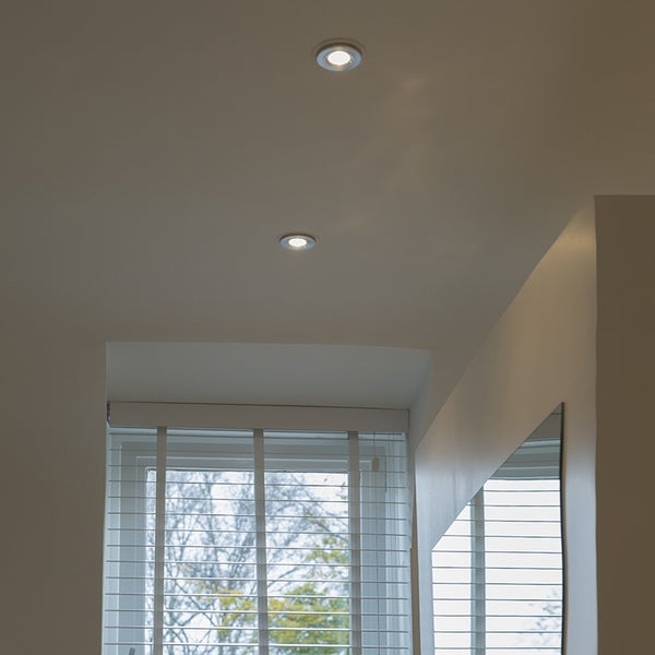 Zwei Deckenleuchten beleuchten einen Raum mit Fensterjalousien und einem Spiegel