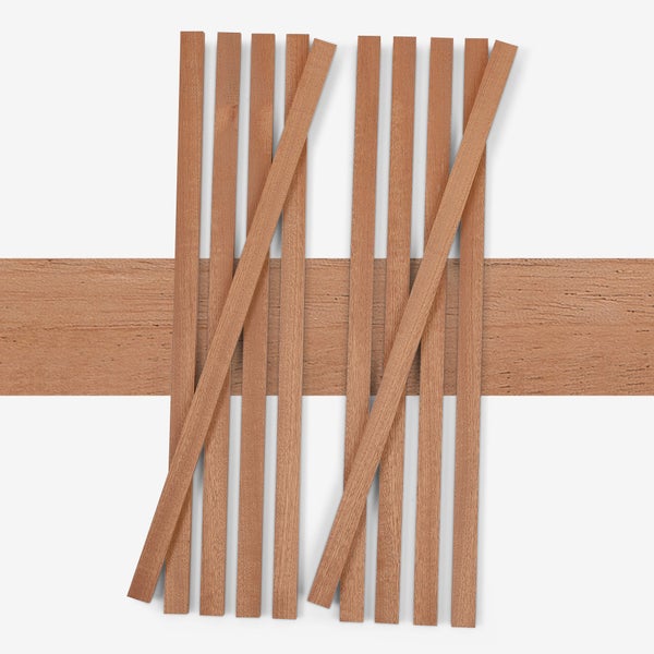 Schmale Holzleisten und eine breitere Holzplanke mit natürlicher Maserung für Modellbau und Bastelarbeiten.