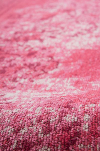 Nahaufnahme der Struktur eines rosa und weiß gewebten Teppichs.