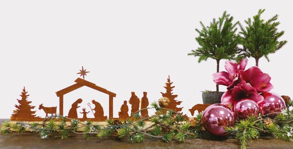 Weihnachtliche Dekoration mit Krippenfiguren, Christbaumkugeln und Tannengrün
