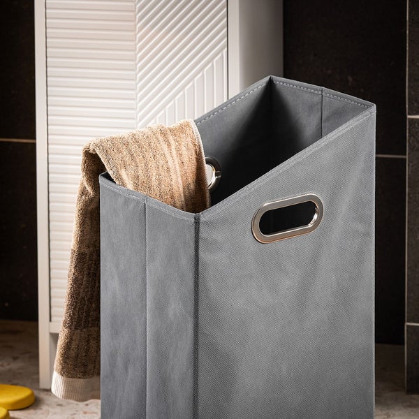 Grauer Wäschesammler mit Handtuch im Badezimmer