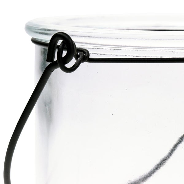 Detailansicht eines Glaswindlichts mit einem schwarzen Henkel aus Metalldraht.