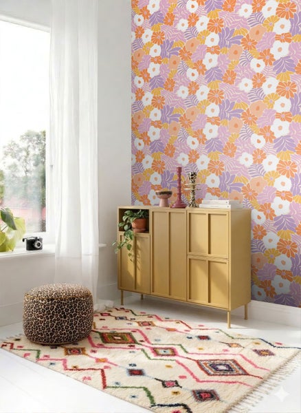 Helles Zimmer mit retro Blumen-Tapete, senfgelbem Sideboard, gemustertem Teppich und einem Hocker im Leopardenmuster.