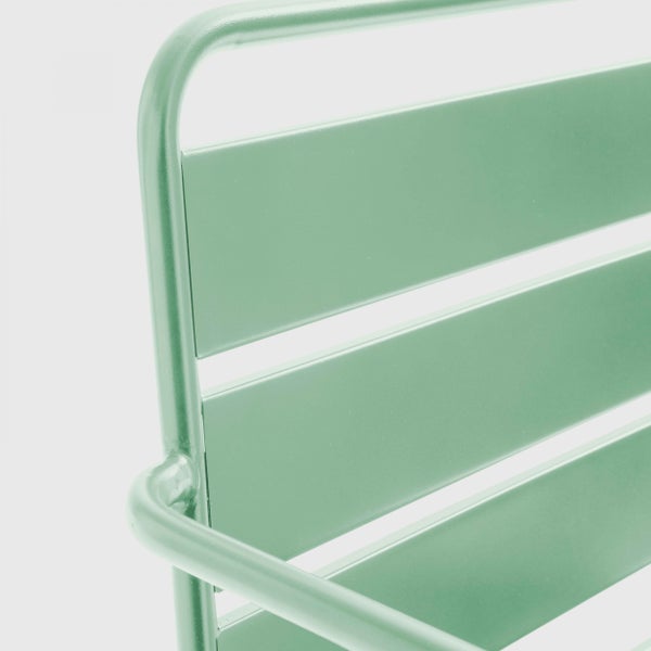 Nahaufnahme einer grünen Gartenbank aus Metall mit Lattung und rechteckiger Griffaussparung in der Sitzfläche.