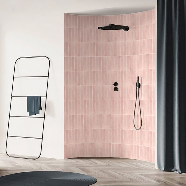 Moderne Dusche mit gebogener Wand, gefliest mit rechteckigen Fliesen, ergänzt durch schwarze Armaturen und einen Handtuchhalter im Badezimmer.