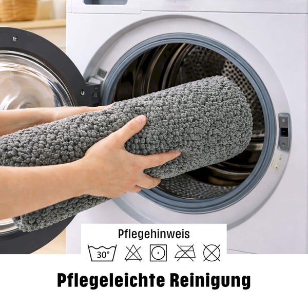 Grauer Badeteppich in Waschmaschine. Pflege: Maschinenwäsche bei 30 Grad, Trocknergeeignet, nicht bleichen, nicht bügeln, keine chemische Reinigung.