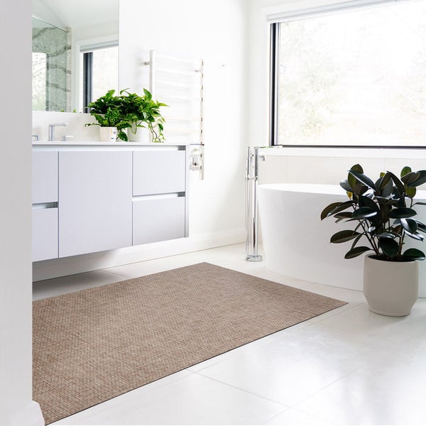 Helles Badezimmer mit Badewanne, Waschtisch und rechteckigem Teppich