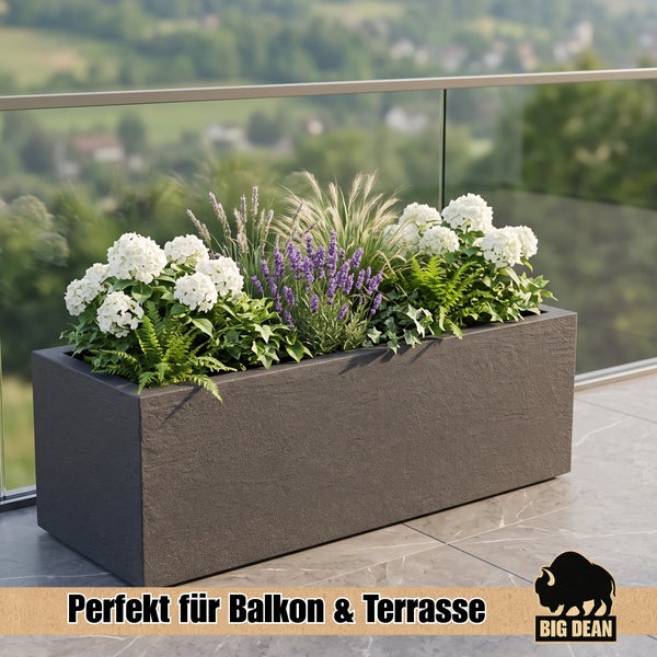 Rechteckiger Pflanzkübel aus Steinoptik mit verschiedenen Blumen und Pflanzen auf einer Terrasse mit Glasgeländer.