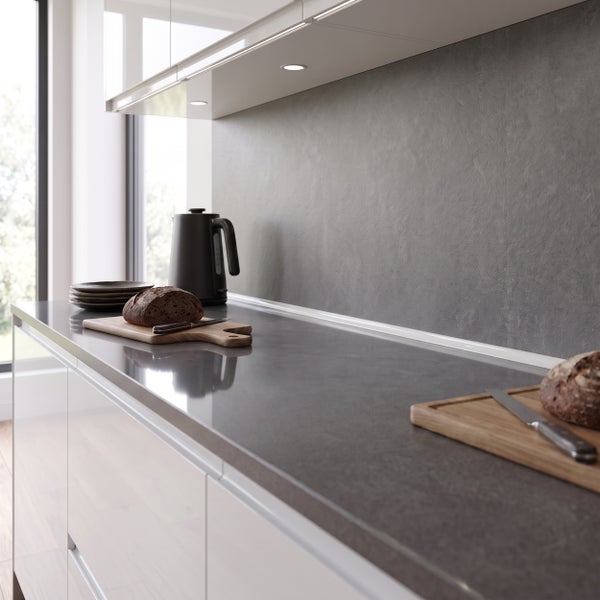 Moderne Kueche mit Arbeitsplatte in Steinoptik, weissen Fronten, Wasserkocher und Broten auf Schneidebrettern.