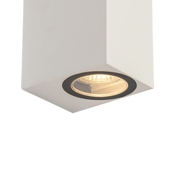Weißer quadratischer Aufbaustrahler mit kreisförmiger, warm leuchtender Lichtquelle von unten gesehen.
