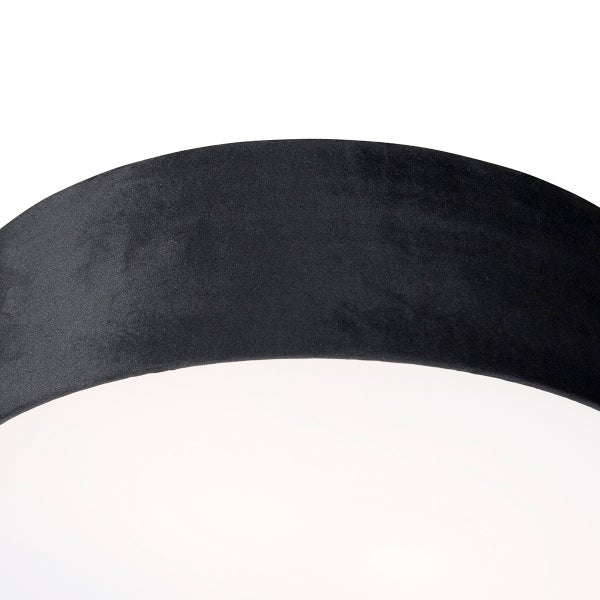 Detailansicht einer schwarzen, matt texturierten Leuchte mit weißem Diffusor.