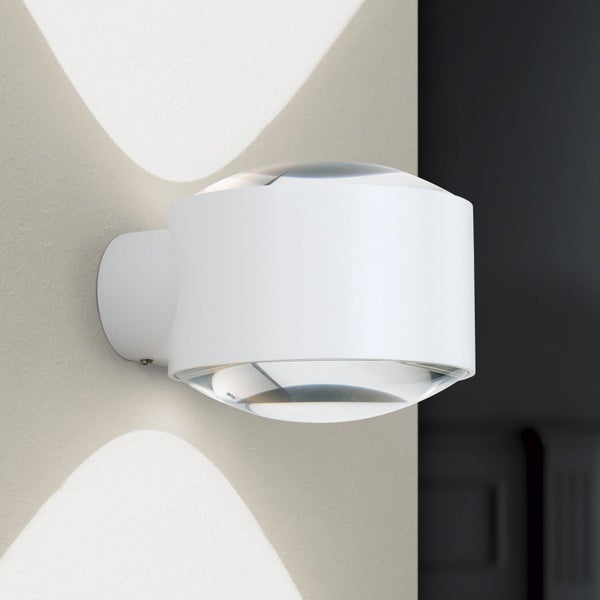 Moderne weiße zylindrische Wandleuchte mit Lichtaustritt nach oben und unten an einer Wand montiert.