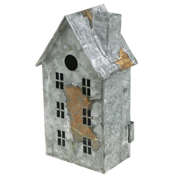 Dekoratives Vogelhaus aus verzinktem Metall mit Fensteraussparungen und Schornstein in Rost-Optik.
