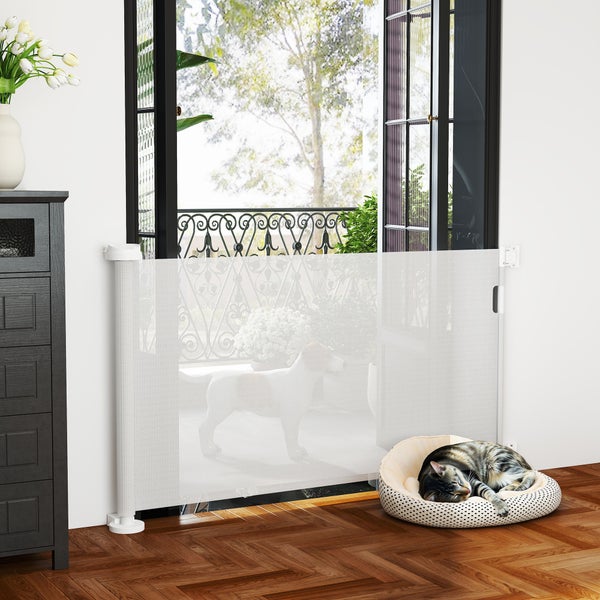 Innenraum mit ausziehbaren Treppenschutzgitter, das einen Durchgang versperrt, mit einer Katze im Katzenbett