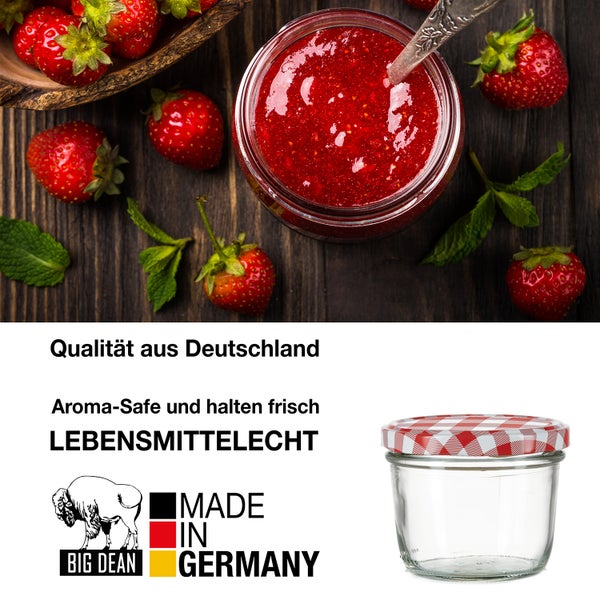 Einmachglas mit rotem Karomusterdeckel, gefüllt mit Erdbeermarmelade, Erdbeeren und Minze