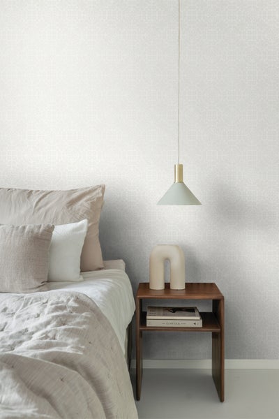 Schlafzimmer mit gemusterter Tapete, Nachttisch und Lampe