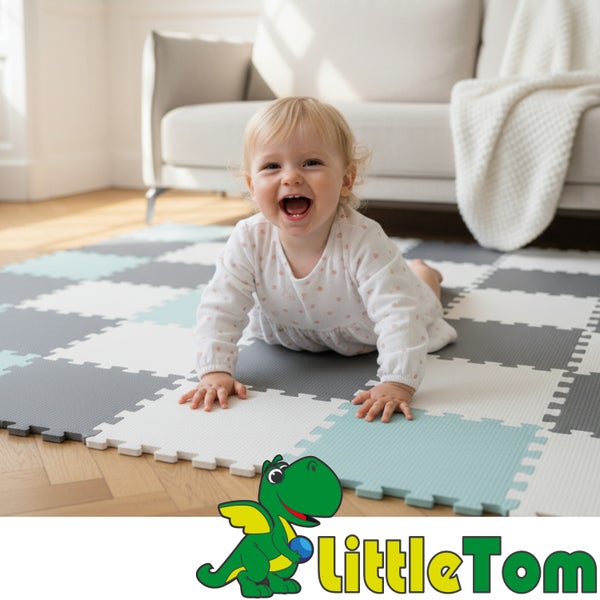 Lachendes Baby auf einer weichen Puzzlematte aus Schaumstoff in einem hellen Wohnzimmer. LittleTom Logo.