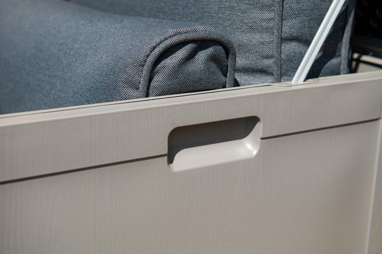 Detail einer Garten Auflagenbox mit integrierter Griffmulde und grauen Polstern