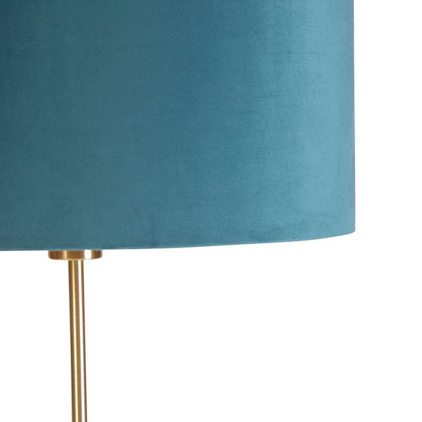 Detail einer Stehlampe mit blauem Stoffschirm und goldenem Gestell
