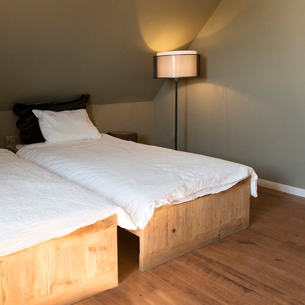 Schlafzimmer mit zwei Einzelbetten, Nachttisch und Stehlampe