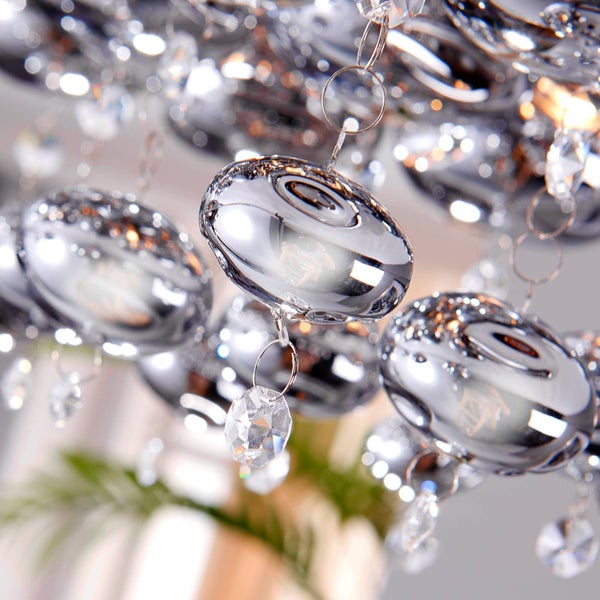 Detailaufnahme einer glänzenden Deckenleuchte mit Kristallelementen.