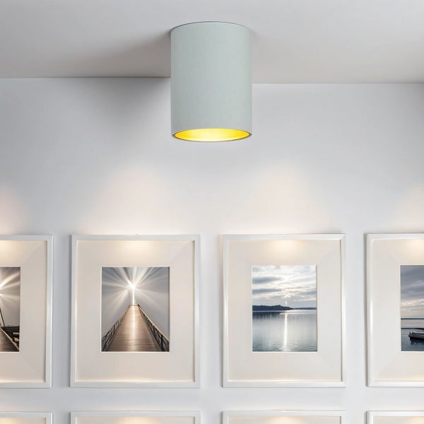 Deckenleuchte über gerahmten Bildern an einer Wand