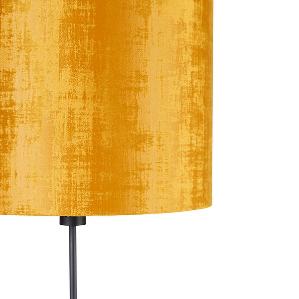 Nahaufnahme eines zylindrischen Lampenschirms aus gelbem Textil mit Struktur auf einem schwarzen Standrohr.