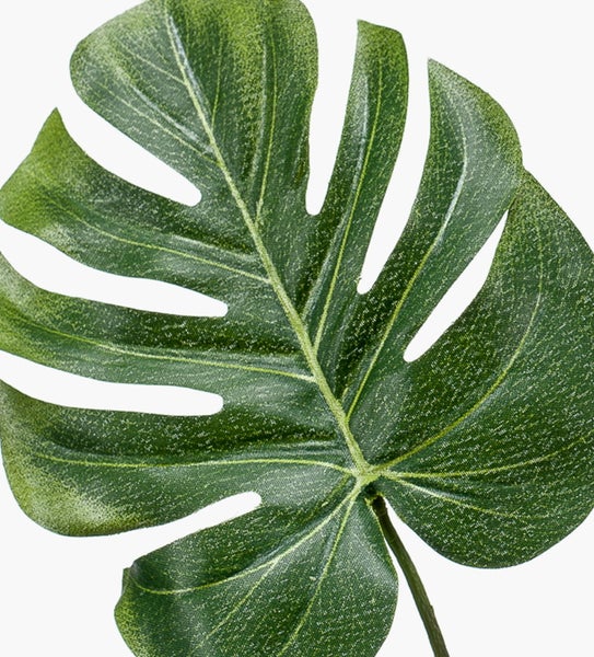Künstliches Monstera-Blatt aus Kunststoff und Textilgewebe mit charakteristischen Blatteinschnitten.