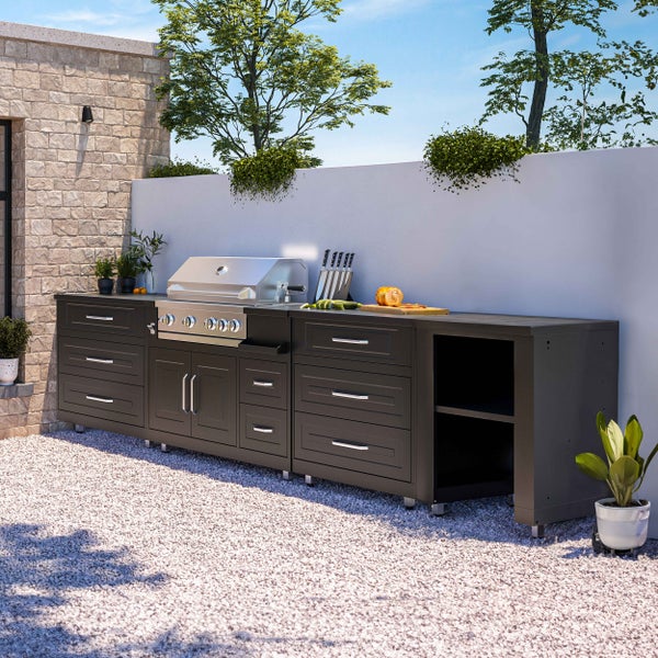 Moderne Außenküche mit integriertem Edelstahl-Gasgrill, anthrazitfarbenen Schränken und viel Stauraum auf einer Kiesfläche.