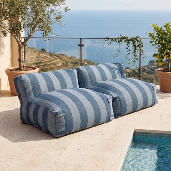 Gestreiftes Outdoor-Sitzsack-Sofa auf einer Terrasse am Pool mit Meerblick.