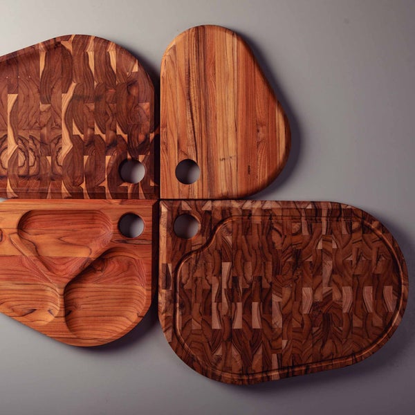 Vier hölzerne Schneidebretter in verschiedenen Formen mit Loch zum Aufhängen.