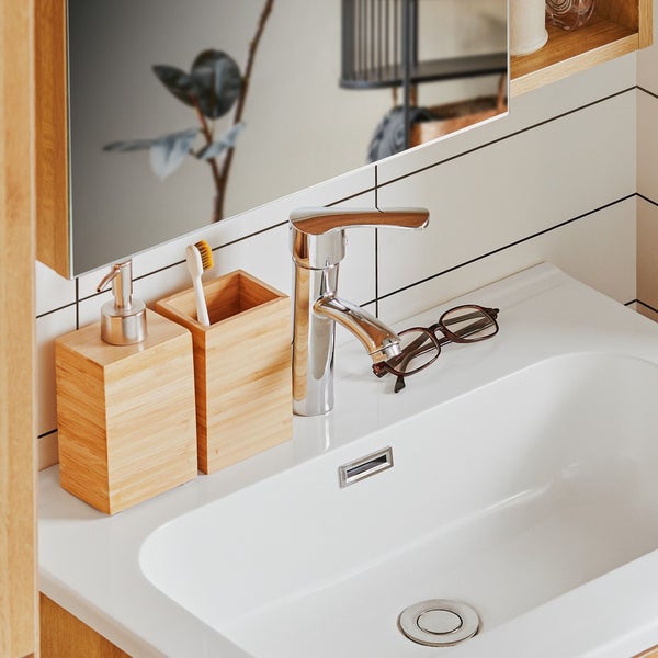 Badezimmerwaschbecken mit Armatur, Seifenspender, Zahnbürstenhalter und Brille