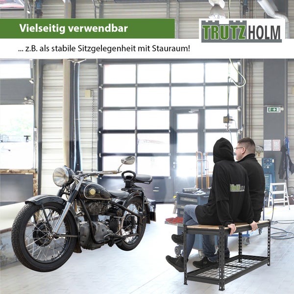 Zwei Personen sitzen auf einer stabilen Trutzholm Werkbank mit Ablagefläche in einer Werkstatt neben einem historischen Motorrad.