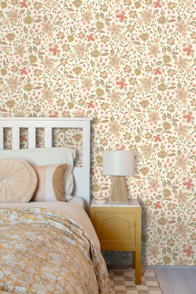 Helle Raumszene mit floral gemusterter Tapete an der Wand, einer offenen weißen Tür und einem Fenster mit Pampasgras.