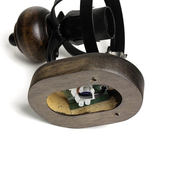 Detailansicht einer Tischleuchte mit Holzfuß und schwarzem Metallgestell