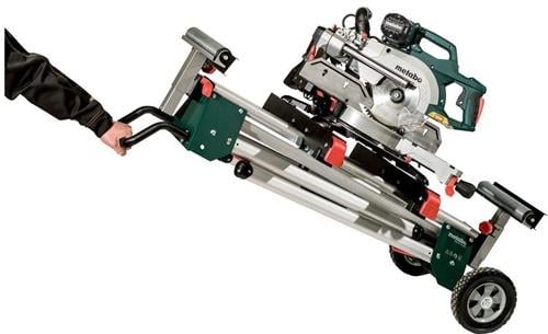 Metabo Logo auf einer Kapp- und Gehrungssäge mit Untergestell und Rädern, die von einer Person gezogen wird