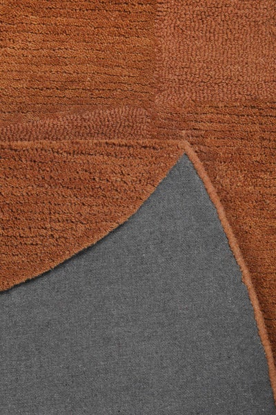 Strukturierter Teppich mit Schlingenflor und glatter Unterseite in der Nahaufnahme mit umgeschlagener Ecke.