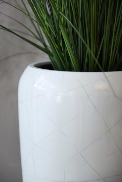 Weißer Keramik-Blumentopf mit Linienmuster und grünem Dekogras