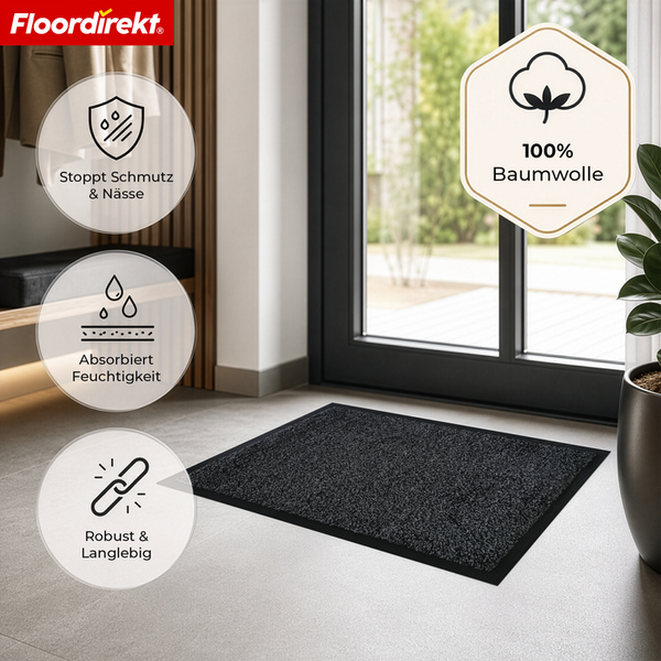 Floordirekt Logo. Schwarze Fußmatte aus 100 Prozent Baumwolle im hellen Eingang. Stoppt Schmutz, absorbiert Feuchtigkeit und ist robust.