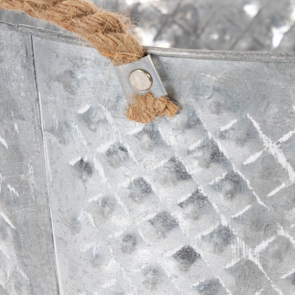Nahaufnahme eines verzinkten Metallgefäßes mit Rautenmuster und einem Griff aus Naturseil.