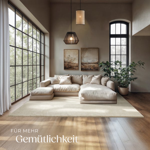 Wohnzimmer mit Sofa, Teppich und Pendelleuchten