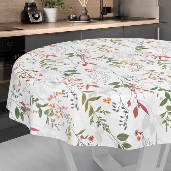 Runde Tischdecke mit floralem Muster aus Blättern und Blüten, auf einem Esstisch in einer modernen Küche drapiert.