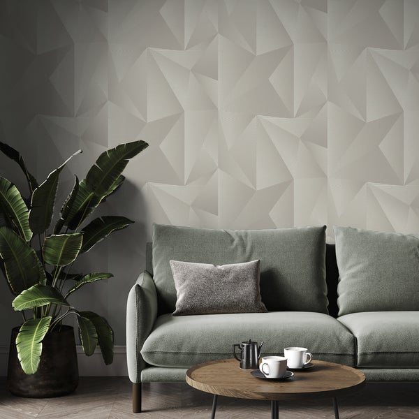 Wohnzimmer mit geometrischer Tapete, grünem Sofa und Zimmerpflanze.