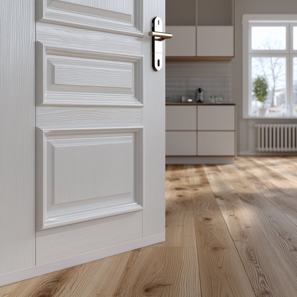 Weiße Innentür mit Kassettenprofil und Metalltürdrücker in modernem Wohnraum mit Holzparkett und Blick in eine Küche