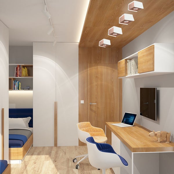 Modernes helles Zimmer mit Holzschreibtisch, zwei Stühlen, Bett mit blauem Bezug, Wandpaneelen aus Holz und quadratischen Deckenstrahlern.